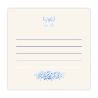 Blue bow and hydrangea sticky notes with lined writing space on an ivory note pad