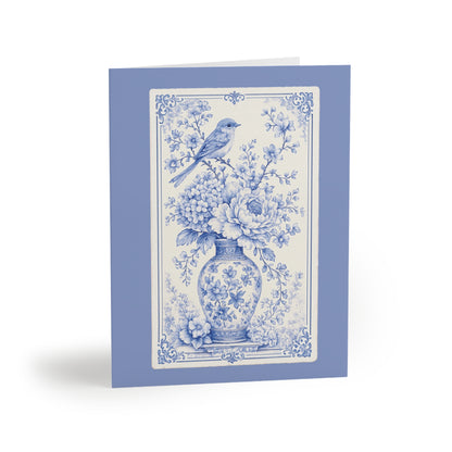 Blue chinoiserie floral greeting card featuring a vintage porcelain vase, blooming flowers, and a delicate bird illustration.
