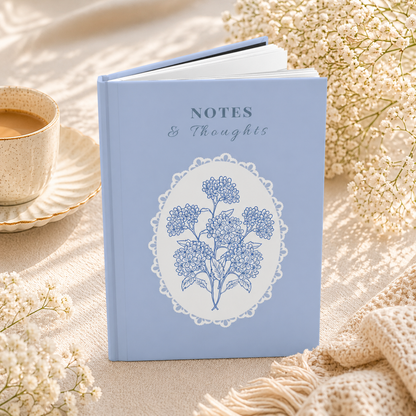 Hardcover blue floral lace notebook angled view showing thickness and matte finish, lined journal for everyday writing
