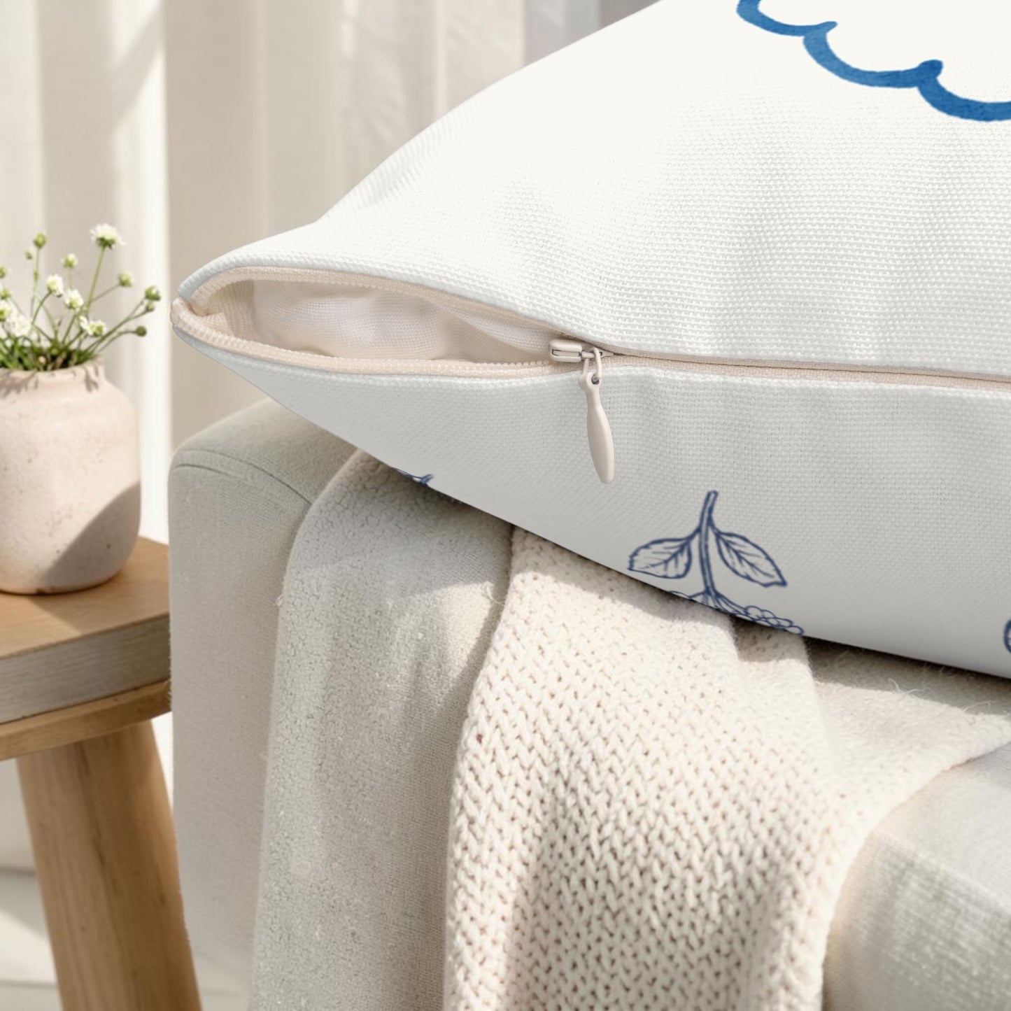 Close-up of blue hydrangea floral pillow showing textured fabric and detailed botanical linework on ivory cushion cover