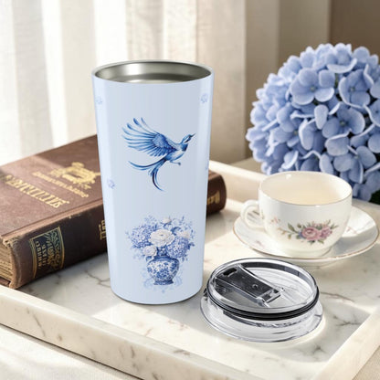 Blue chinoiserie bird tumbler styled with vintage books and hydrangeas in a cozy reading nook setting