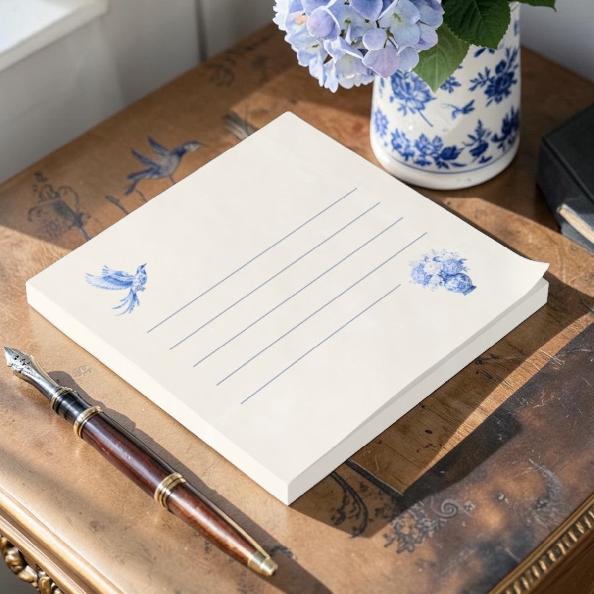 Decorative blue bird floral sticky note pad on a vintage-inspired writing desk with elegant stationery accessories