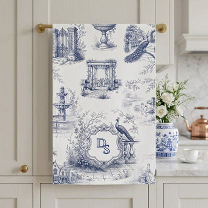 Personalized blue toile tea towel with monogram hanging in a light traditional kitchen.