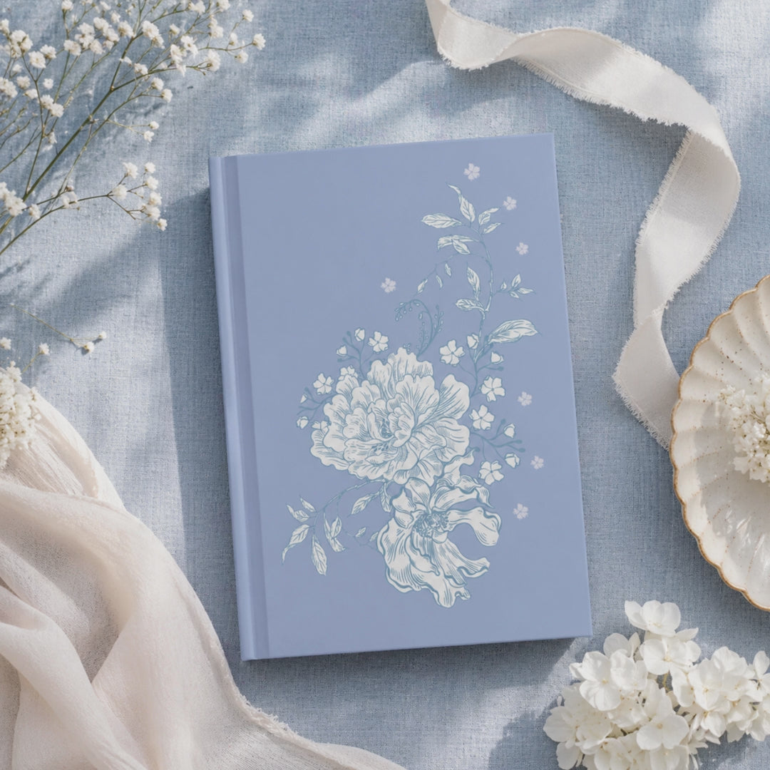 Open lined pages of blue floral hardcover journal with flat lay aesthetic background