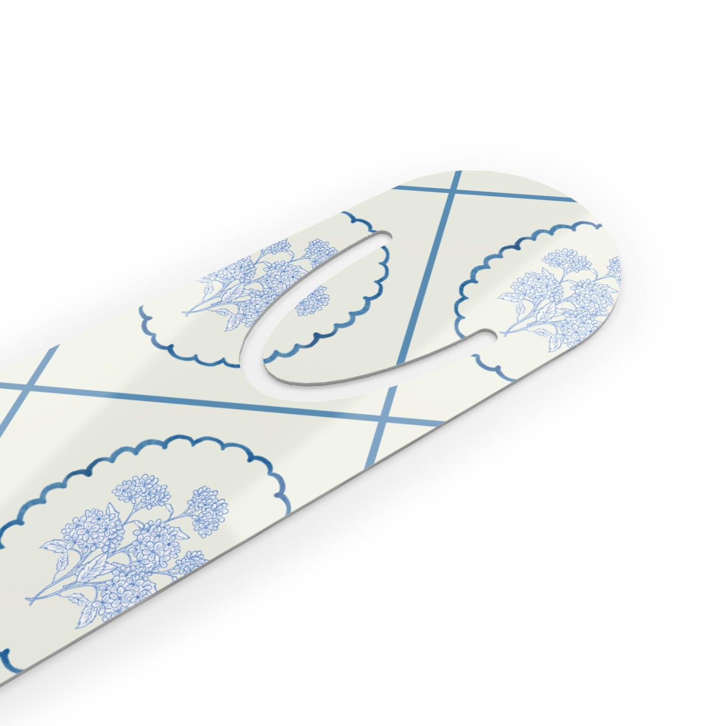 Close-up angled view of a blue Delft floral metal bookmark featuring a delicate ceramic-inspired pattern