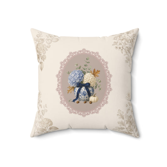 Vintage floral throw pillow featuring a hydrangea bouquet in a porcelain vase with a navy ribbon, framed by an elegant lace-inspired medallion.